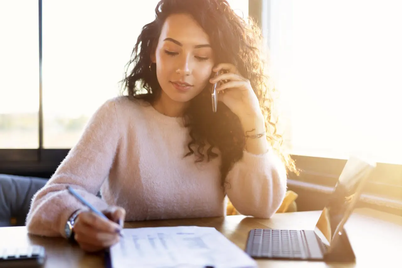 Eventmanagerin am Telefon mit Notizen